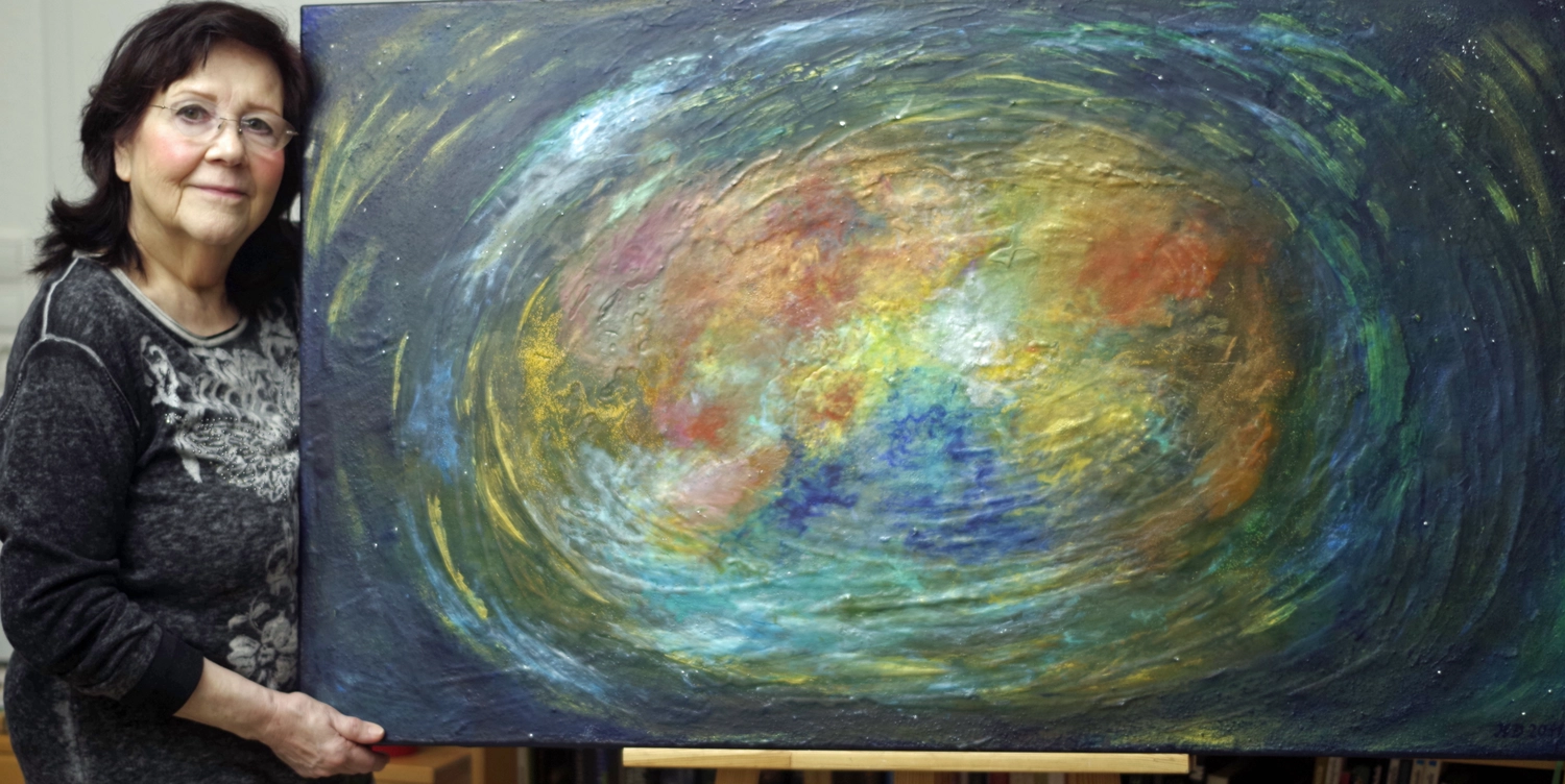 Hannelore Drees-Kiefhaber - Acrylmalerei von der Nordseeküste - Stephanie Drees in einem schwarz-weißen Oberteil steht neben ihrem abstrakten Gemälde.