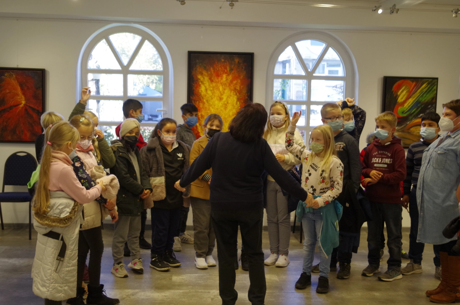 Hannelore Drees-Kiefhaber - Acrylmalerei von der Nordseeküste - Eine Gruppe Kinder und ein Erwachsener stehen in einer Kunstgalerie, einige tragen Gesichtsmasken.