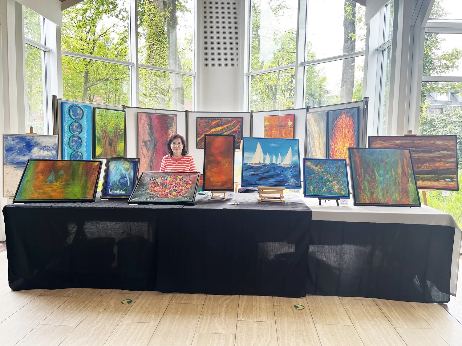 Hannelore Drees-Kiefhaber - Acrylmalerei von der Nordseeküste - Vier Personen unterhalten sich in einer Kunstgalerie oder einem hellen Raum mit einem großen abstrakten Gemälde an der Wand.